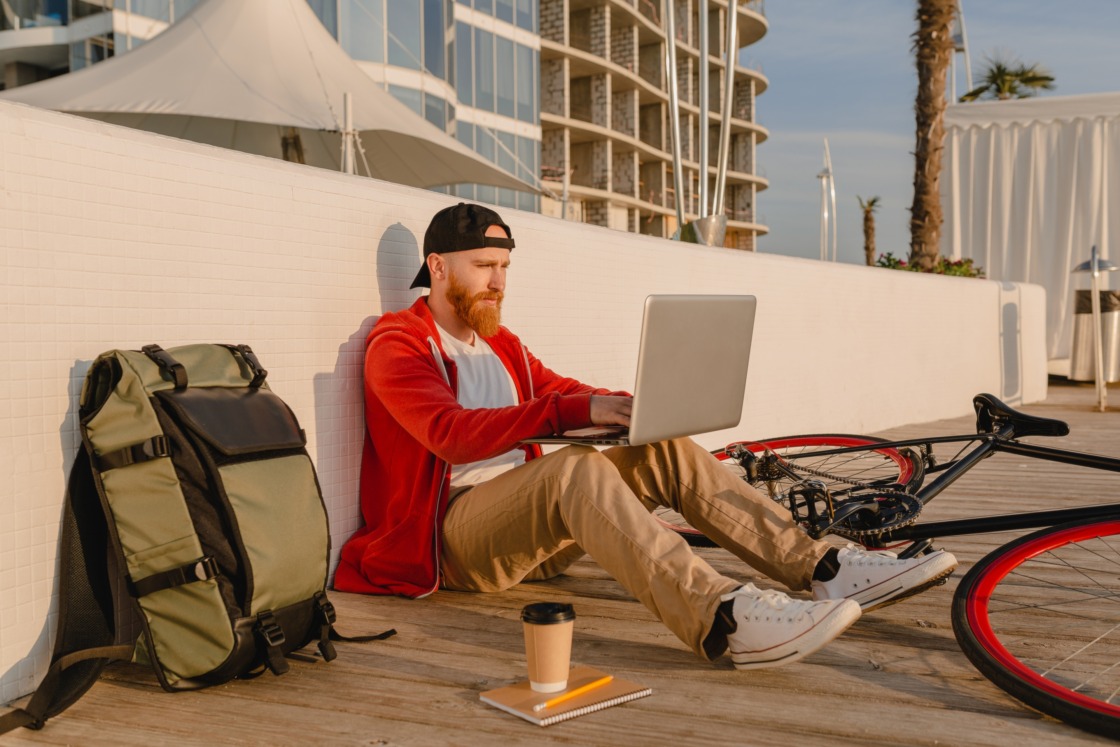 handsome bearded man traveling with bicycle in morning What do digital nomads do? Pros & cons, must-have skills, and daily routines
