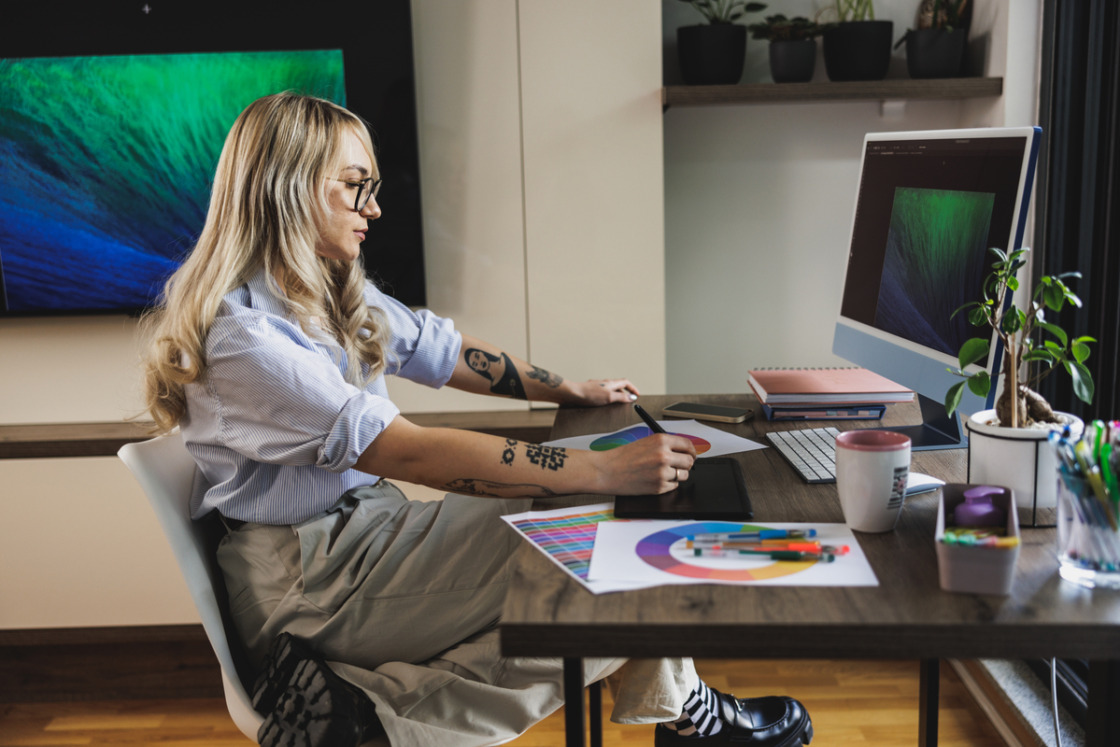 Kobieta graficzka, pracująca przy komputerze w domu nad kreatywnym projektem