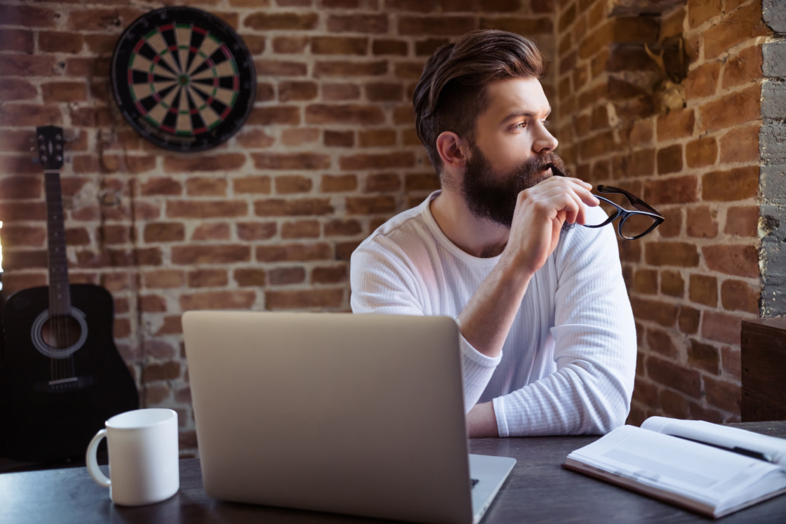 IKE i IKZE dla freelancerów Młody mężczyzna pracujący zdalnie zastanawia się nad ike i ikze